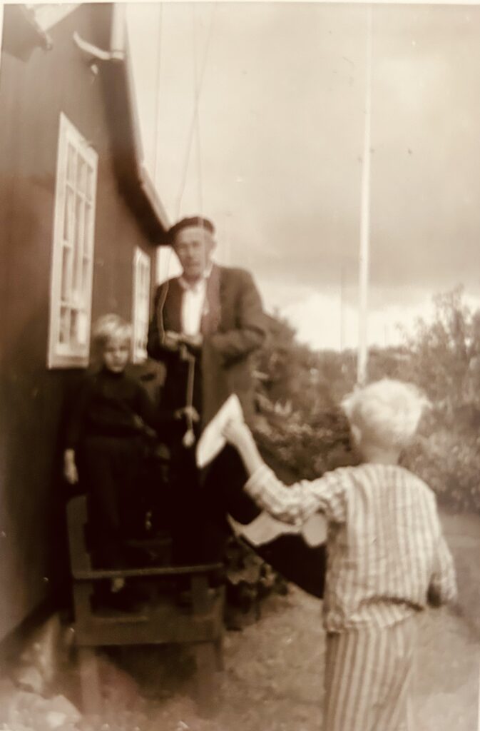Georg Palmkvist Knudsen hejser flaget i kolonihaven sammen med Per og Ole